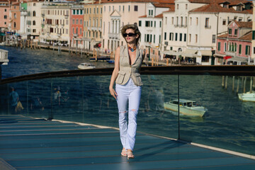 Fototapeta na wymiar Fashion woman in sexy fashion dress enjoying the view of venice italy. Traveling to venice. Woman travel on weekends getaway. Journey concept. Summer travel in venice.