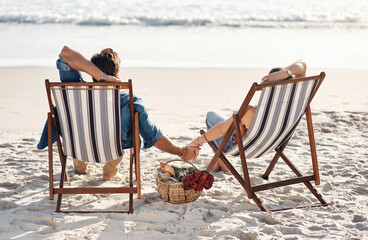 Tranquility is what were after. Rearview shot of a middle aged couple sitting in their beach chairs on the the beach.