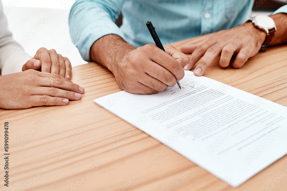 Poster signing on the dotted line. two unrecognizable young business colleagues going over some documents i