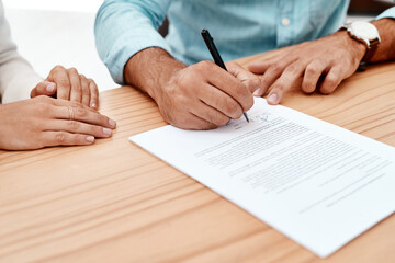 Signing on the dotted line. two unrecognizable young business colleagues going over some documents in the boardroom.