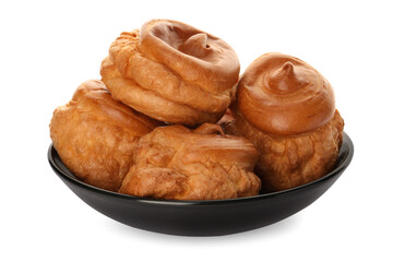 Pile of delicious profiteroles on white background