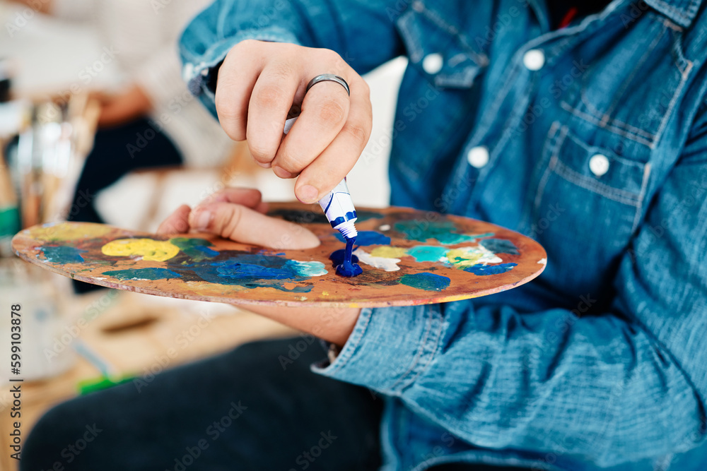 Poster choosing to live a colourful life. an unrecognizable artist squeezing paint onto a palette during an