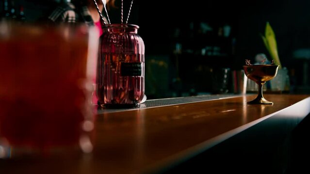 the bartender gives the customer a delicious freshly prepared raspberry milk punch cocktail from the bar counter