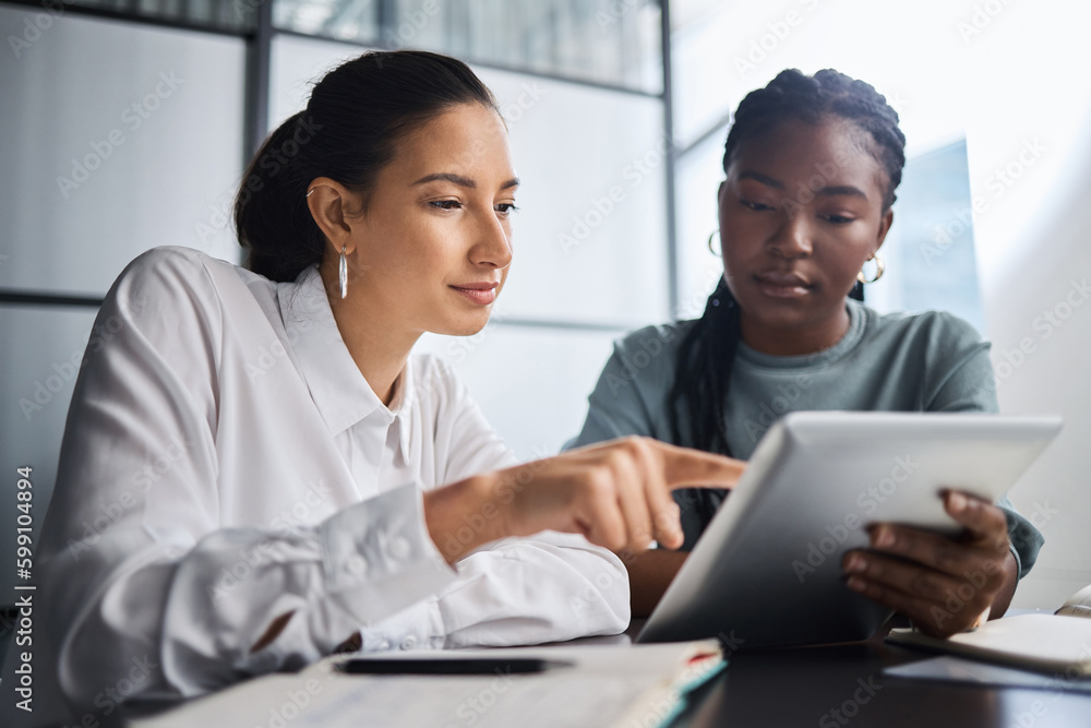 Poster managing all they need with a few taps. two businesswomen working together on a digital tablet in an