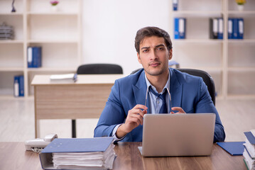 Young male employee and too much work in the office