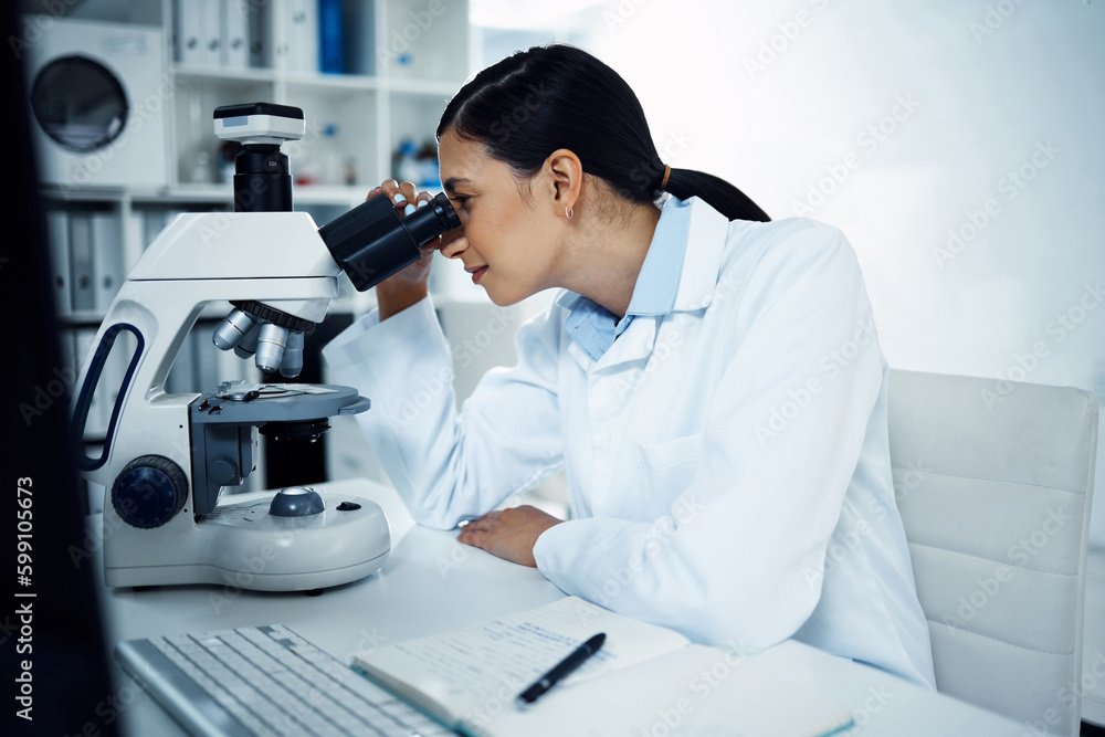 Poster So much to see under the lens. a young scientist using a microscope in a laboratory.