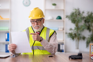 Old male architect sitting in the office