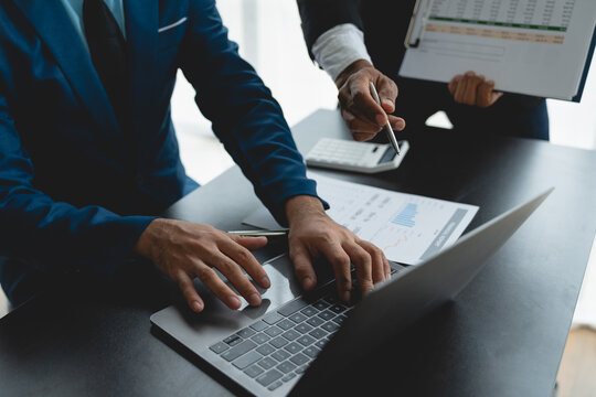 Group of business people meeting about business plans Presenting and explaining financial charts of partners from papers, graphs and data on laptop computer at office.