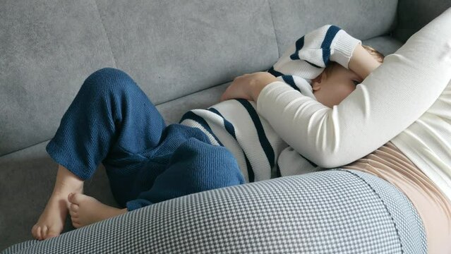 Slow motion of a mother nurturing her baby boy with breast milk on the sofa. Concept of maternal love, child development, and the importance of natural nutrition