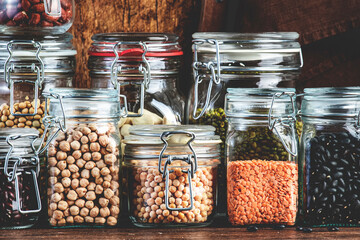 Dried, raw and fresh legumes and beans in glass jars. Lentils, chickpeas, mung beans, soybeans....