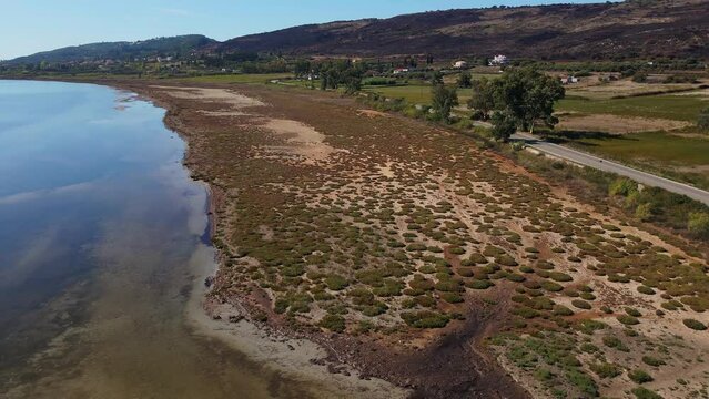 Drone flying across swampy sand bank and a shallow part of the Ionian sea between Lixouri and Livadi with mountains in the background