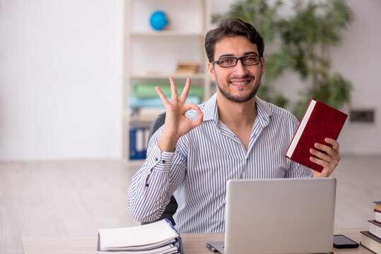 Young male employee student working in the office