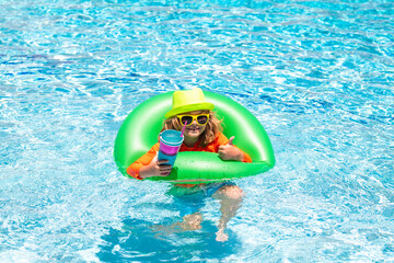 Cute funny child boy relaxing with toy swimming ring in a swim pool having fun during summer vacation in a tropical resort. Kids on sea beach.