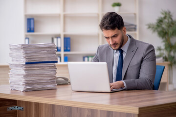 Fototapeta premium Young male employee and too much work in the office