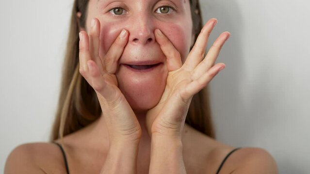 close up retrato belleza cabeza mujer joven cauc&aacute;sica practicando ejercicios de yoga facial con las manos en estudio