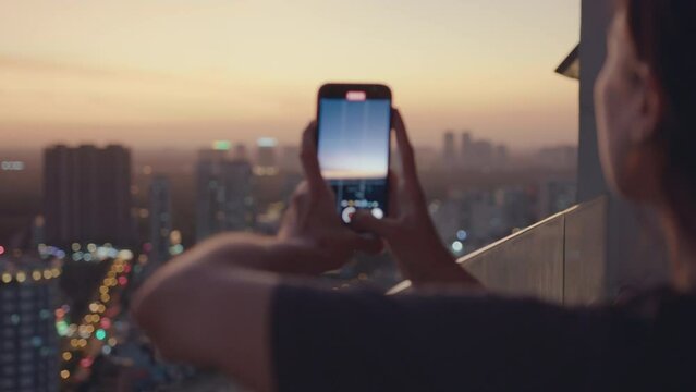 happy woman using smartphone taking photo of beautiful sunset enjoying sharing summer vacation travel experience on balcony