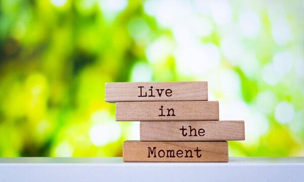 Wooden blocks with words 'Live in the Moment'.