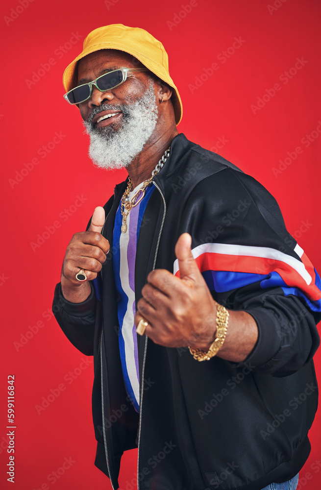 Poster hes super approachable. studio shot of a senior man wearing retro attire while posing against a red 