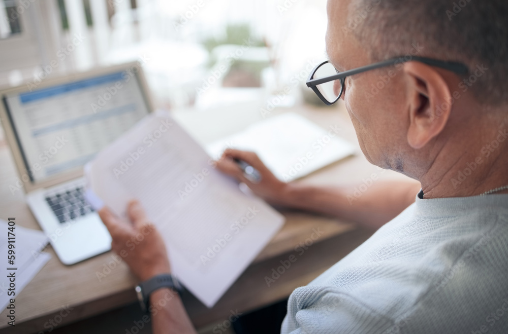 Poster always read the fine print. a mature man reading over financial documents while working.
