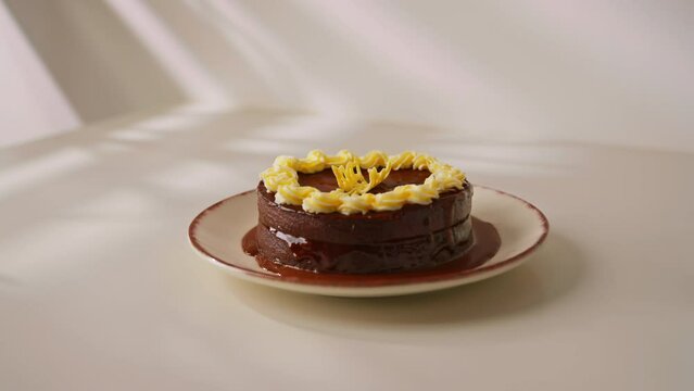 delicious chocolate cake Sacher or Prague cake on a white background decorated with custard laying out figures of white chocolate