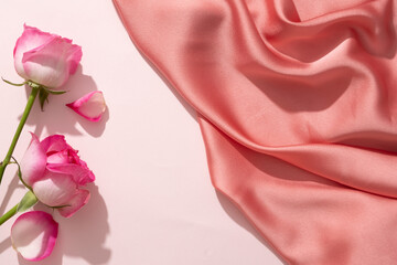 Roses decorated on a white background with a luxurious pink fabric. Blank space in the middle for...