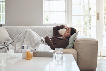 My temperature hasnt gone down. a young woman lying on a sofa while feeling sick at home.