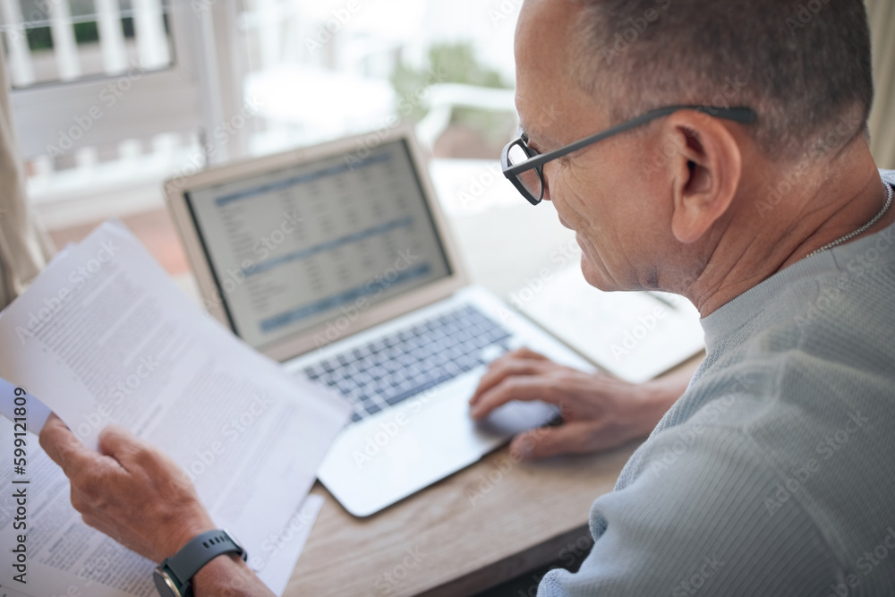 Poster these contacts seem in order. a mature man reading over financial documents while working.