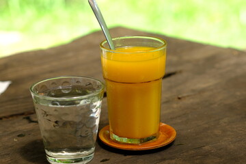 mango juice and water on wooden table. refreshment drink. 