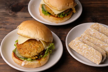 Burger Tempe is burger with tempeh filling. Bun bread, stuffed with processed tempeh, sliced cheese, sliced tomatoes, lettuce, mayonnaise, and tomato sauce. healthy burgers, suitable for vegans. Diet