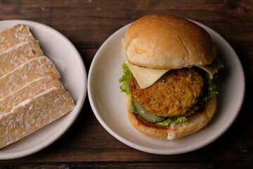 Burger Tempe is burger with tempeh filling. Bun bread, stuffed with processed tempeh, sliced cheese, sliced tomatoes, lettuce, mayonnaise, and tomato sauce. healthy burgers, suitable for vegans. Diet