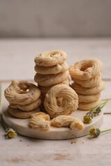 Cheese cookies on a white wooden table. Cookies are dry bread baked in the oven, made from wheat flour, eggs, sugar, cheese and other ingredients. White cheese cookie. sagu keju. 