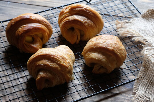 croissants on a cooling rack. croissant, which originated in France, is so named because of its shape resembling a crescent moon. made from wheat, eggs, salt, margarine. Cheese croissants. 