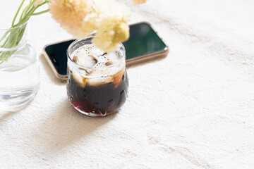 アイスコーヒーと花とスマートフォン