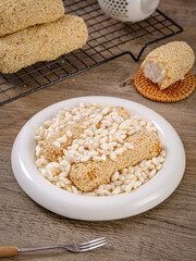 Sesame cakes, traditional Chinese pastry, strips of glutinous rice cakes wrapped with white sesame seeds, on a kitchen table