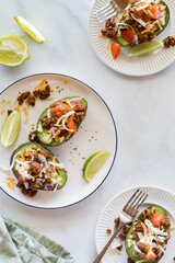 Top down view of plates of Mexican style avocado boats, ready for eating.