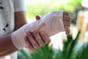 Man with painful wrist due to overuse or sport accidental.He hold his hand and strapping by elastic...