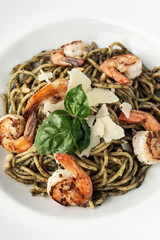 Spaghetti gamberi pasta with prawns and pesto on white background