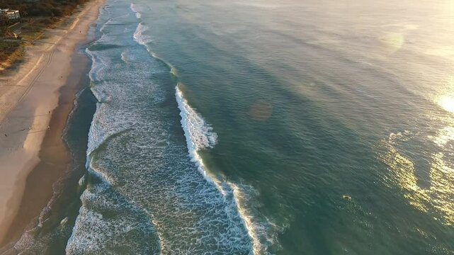 Aerial reverse over Main beach and ocean at sunrise, Gold Coast Australia