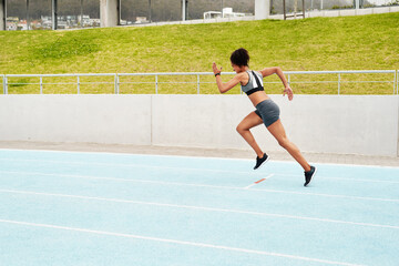 Obraz premium The finish line is my only limit. Full length shot of an attractive young athlete running a track field alone during a workout session outdoors.