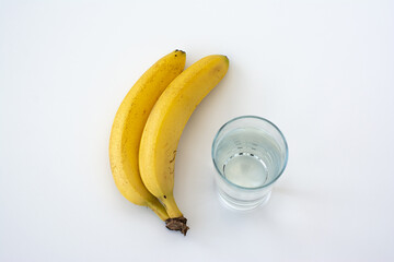 Banana and glass of water isolated on white background