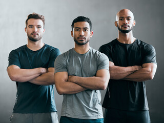 Theyre a confident bunch. Cropped portrait of three handsome young male athletes standing with their arms folded against a grey background. - Powered by Adobe