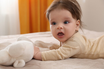 Fototapeta premium Cute little baby with toy on bed indoors. Space for text