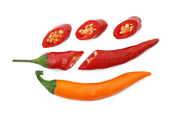 Cut and whole hot chili peppers on white background, flat lay