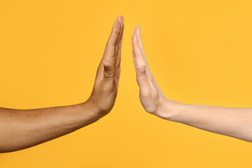 International relationships. People giving high five on orange background, closeup