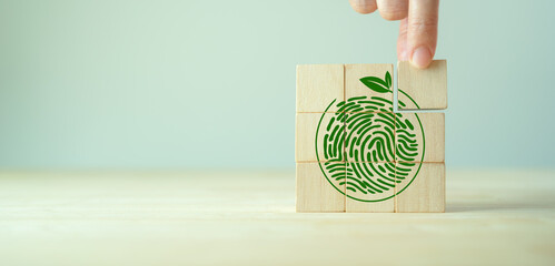 Green fingerprint with leaf on wooden cube blocks. World environment day or earth day concept....