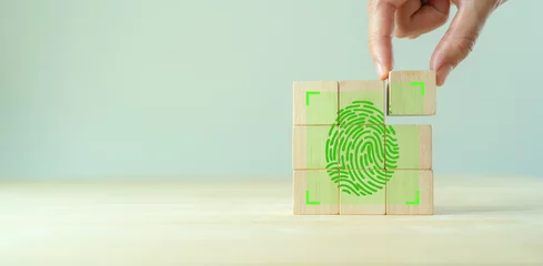 Fotobehang Fingerprint scanning identification system. Biometric authorization and personal security. Green fingerprint with green transparency light on wooden cube blocks on clear background and copy space. © Parradee