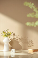 Vases and objects on the table in a warm room with sunlight coming in