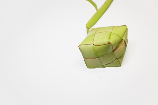 Ketupat pouch on isolated white background. Ketupat or kupat or tipat is a Javanese rice cake packed inside a diamond-shaped container of woven palm leaf pouch. 