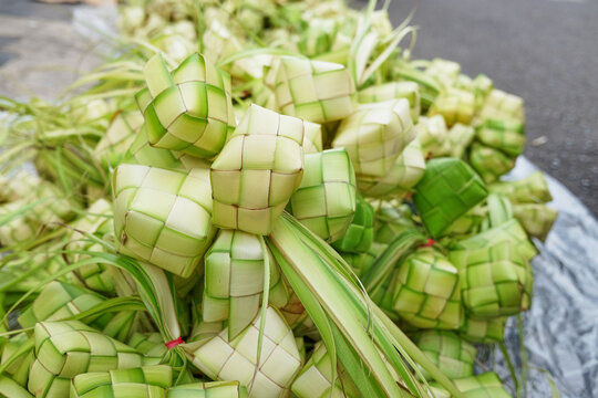 Ketupat pouchs in traditional market. Ketupat or kupat or tipat is a Javanese rice cake packed inside a diamond-shaped container of woven palm leaf pouch. 