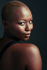 Just be yourself, darling. a beautiful woman wearing colorful eyeshadow while posing against a grey background.